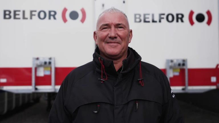 een portret van een BELFOR-medewerker voor een werkvoertuig