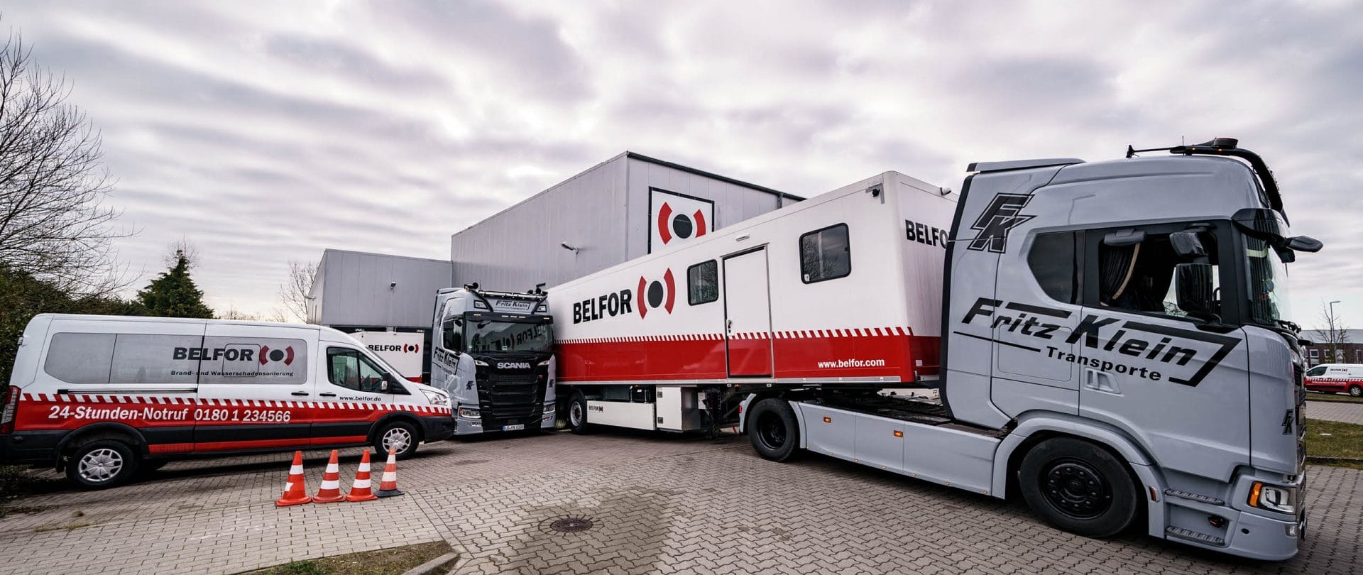 Ein BELFOR-Lkw, der neben einem Anhänger auf einem Parkplatz geparkt ist