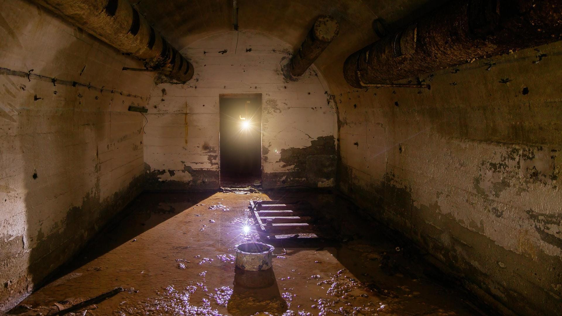 Flooded round abandoned bunker with water reflection.