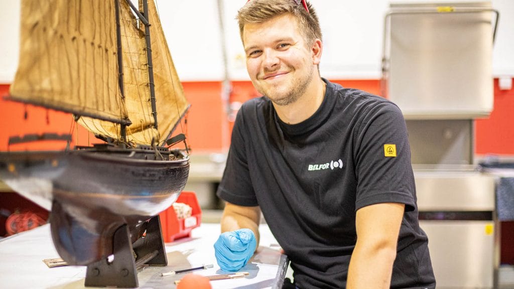Un employé de BELFOR portant une chemise noire et souriant