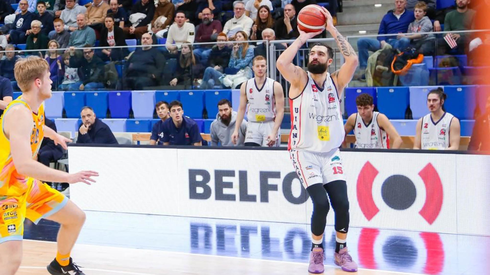 Un giocatore di basket al tiro con la pubblicità BELFOR sullo sfondo.