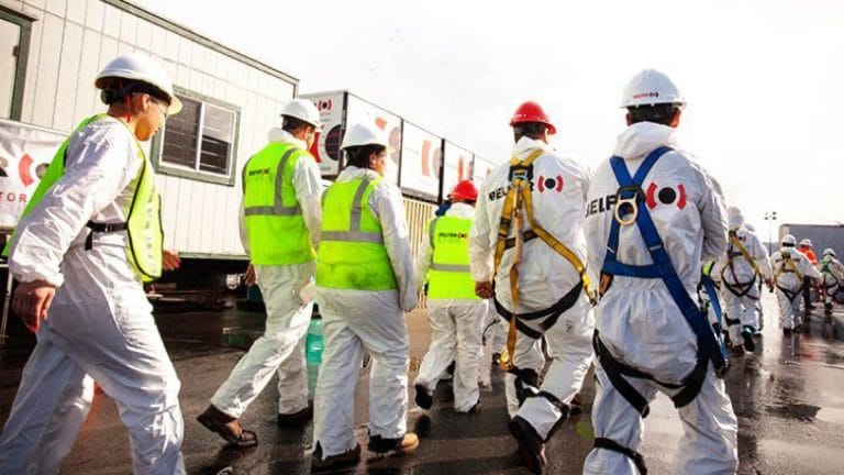 Collaboratori BELFOR in tuta protettiva mentre si recano al lavoro