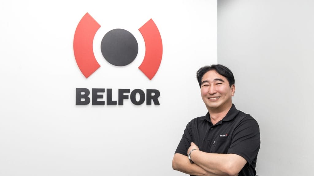 belfor-staff-poses-in-front-of-the company-logo-highlighting-the-brand-identity-and-corporate-image