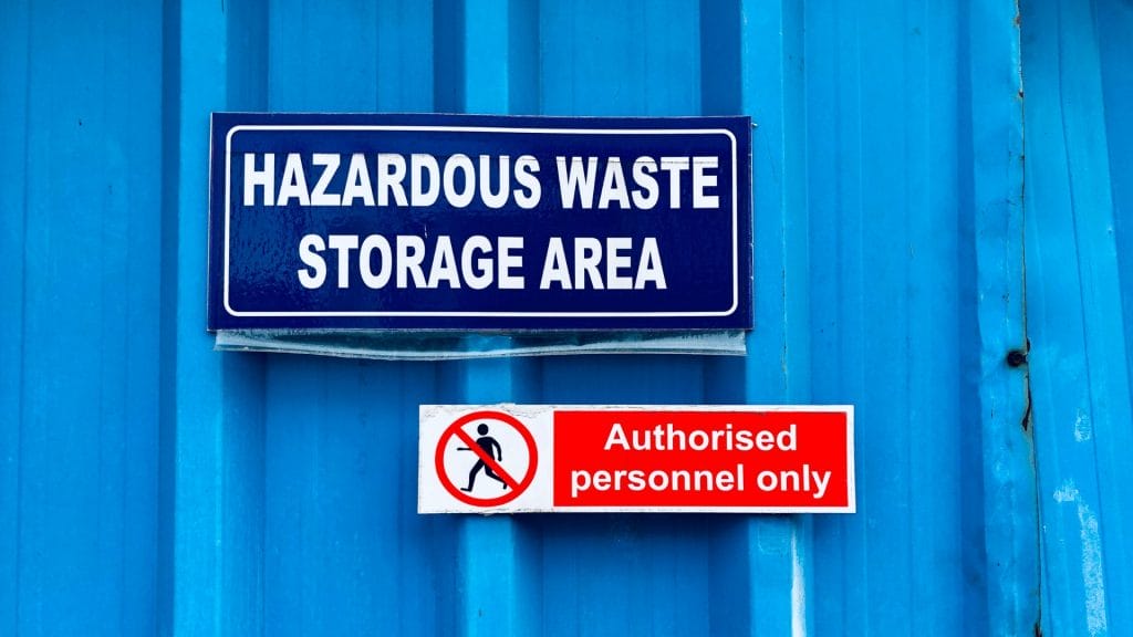 Warning signs alerting about Hazardous Waste storage area.