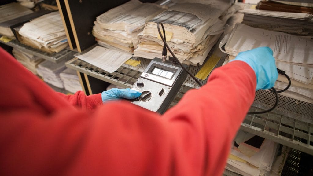 Een medewerker test een apparaat terwijl hij chirurgische handschoenen draagt