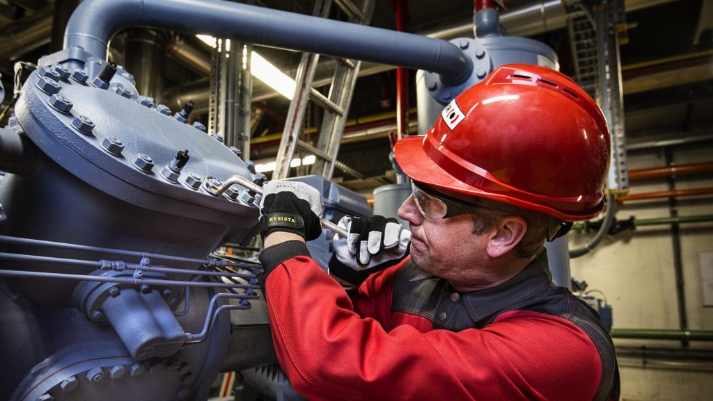 BELFOR technicus draait een bout vast op een machine