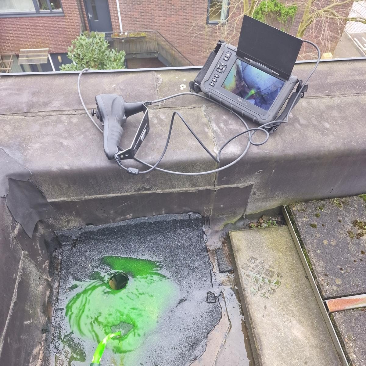 Meetapparaat en groen water op een dak