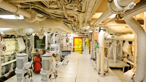 A ship's engine room featuring an array of pipes and valves, showcasing the complex plumbing system.