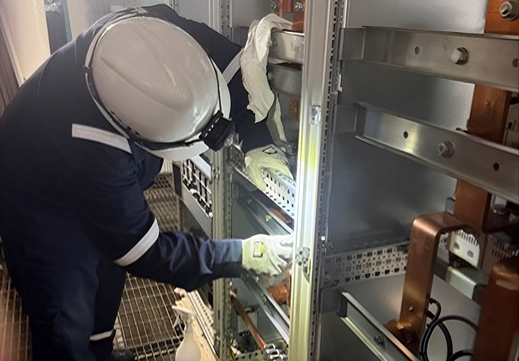 A BELFOR recovery technician is decontaminating electrical systems aboard an offshore vessel that suffered an oil leak.