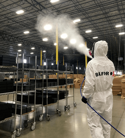 BELFOR technician uses fogger or sprayer to sanitize warehouse