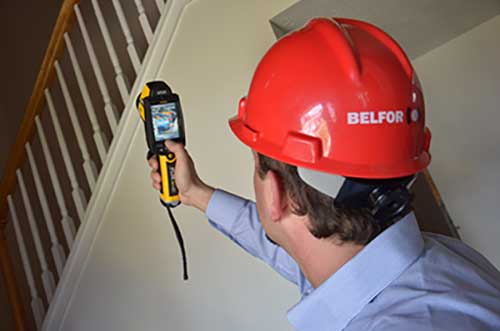 BELFOR technician measures water damage with infrared camera