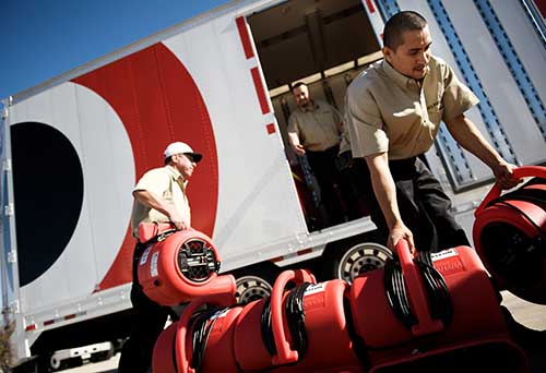 BELFOR technicians load air movers and water remediation equipment