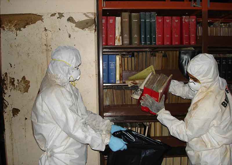 BELFOR technicians remove molded books from library