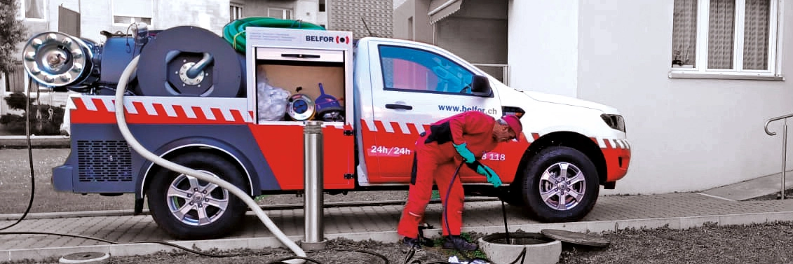 Ein Mitarbeiter von Belfor vor seinem Einsatzwagen. Er säubert einen Schacht.