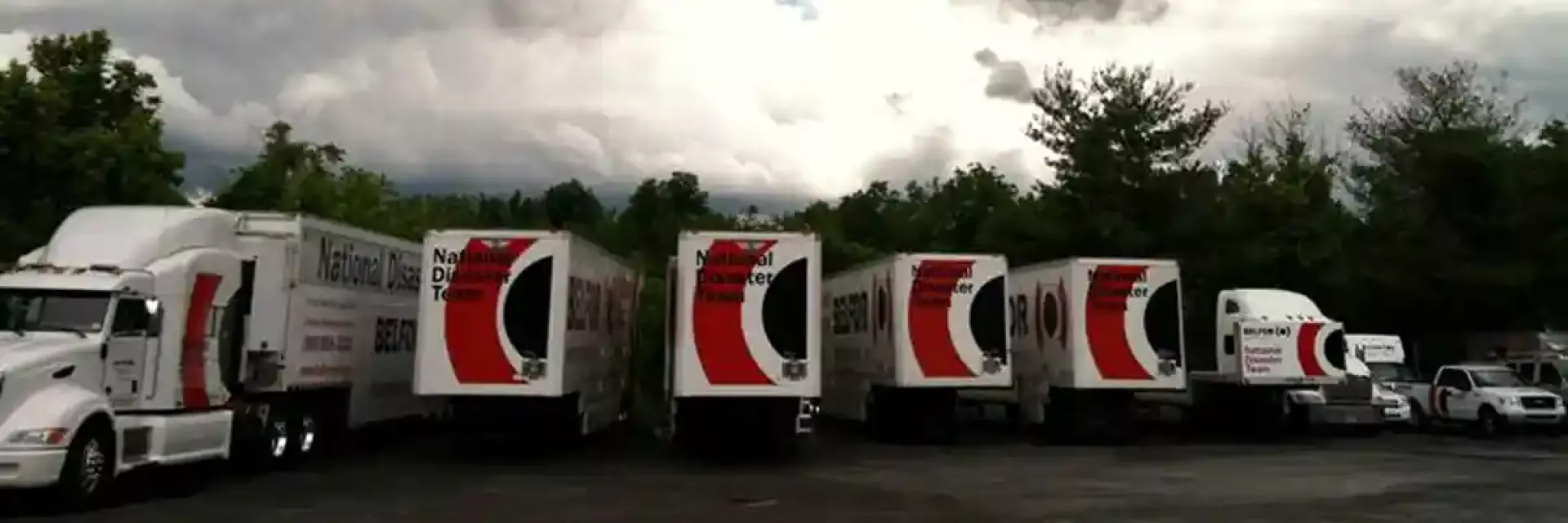 BELFOR truck fleet under dark sky