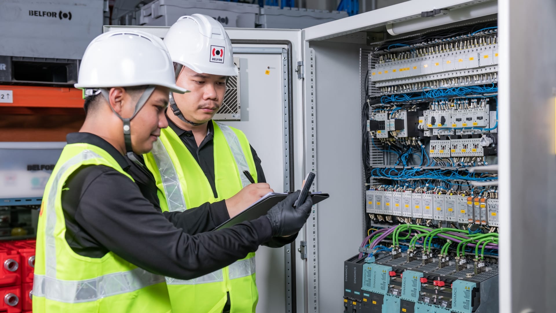 belfor-technicians-in-safety-vests-inspecting-a-panel-demonstrating-teamwork-in-an-industrial-facility