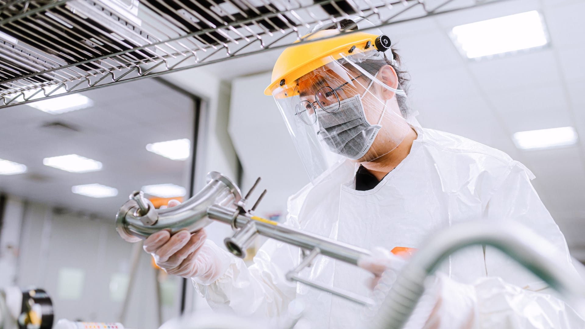 belfor-technician-in-protective-gear-and-face-shield-inspects-semiconductor-components-in-a-cleanroom